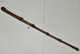 A BRIAR WOOD HAND CARVED WALKING STICK, carved face handle with foliage to top of shaft, carved