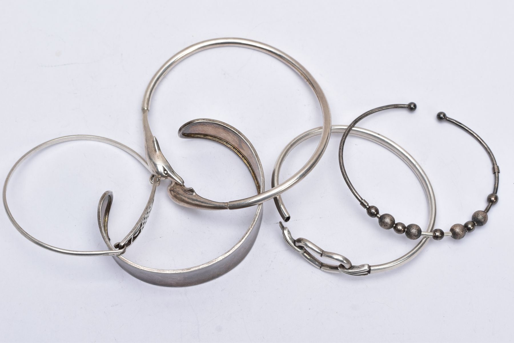 A BAG OF ASSORTED SILVER AND WHITE METAL BANGLES, to include three silver bangles such as a mother