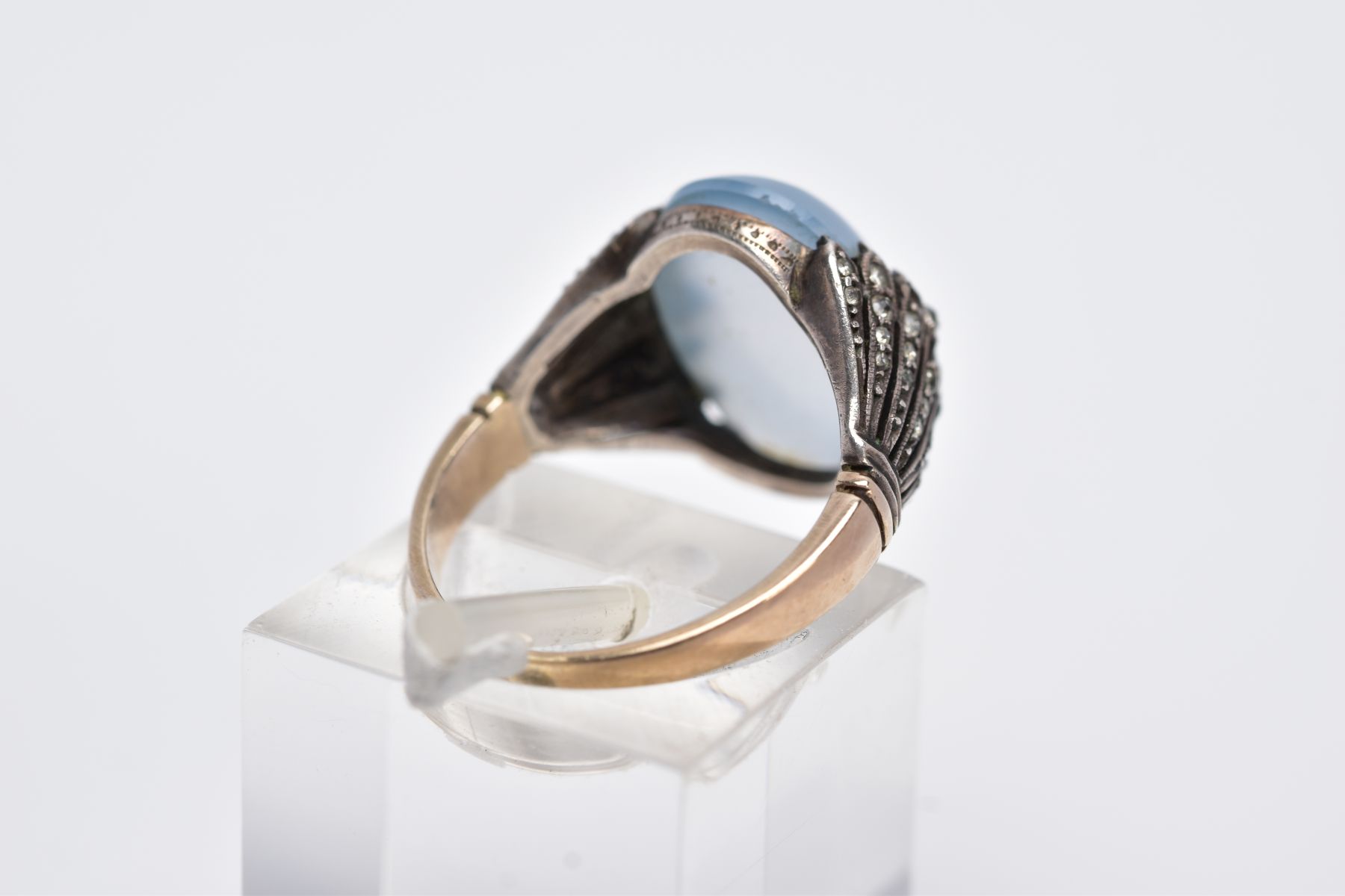 A YELLOW METAL GEM SET RING, designed with a milky chalcedony cabochon, openwork feathered shoulders - Image 3 of 4