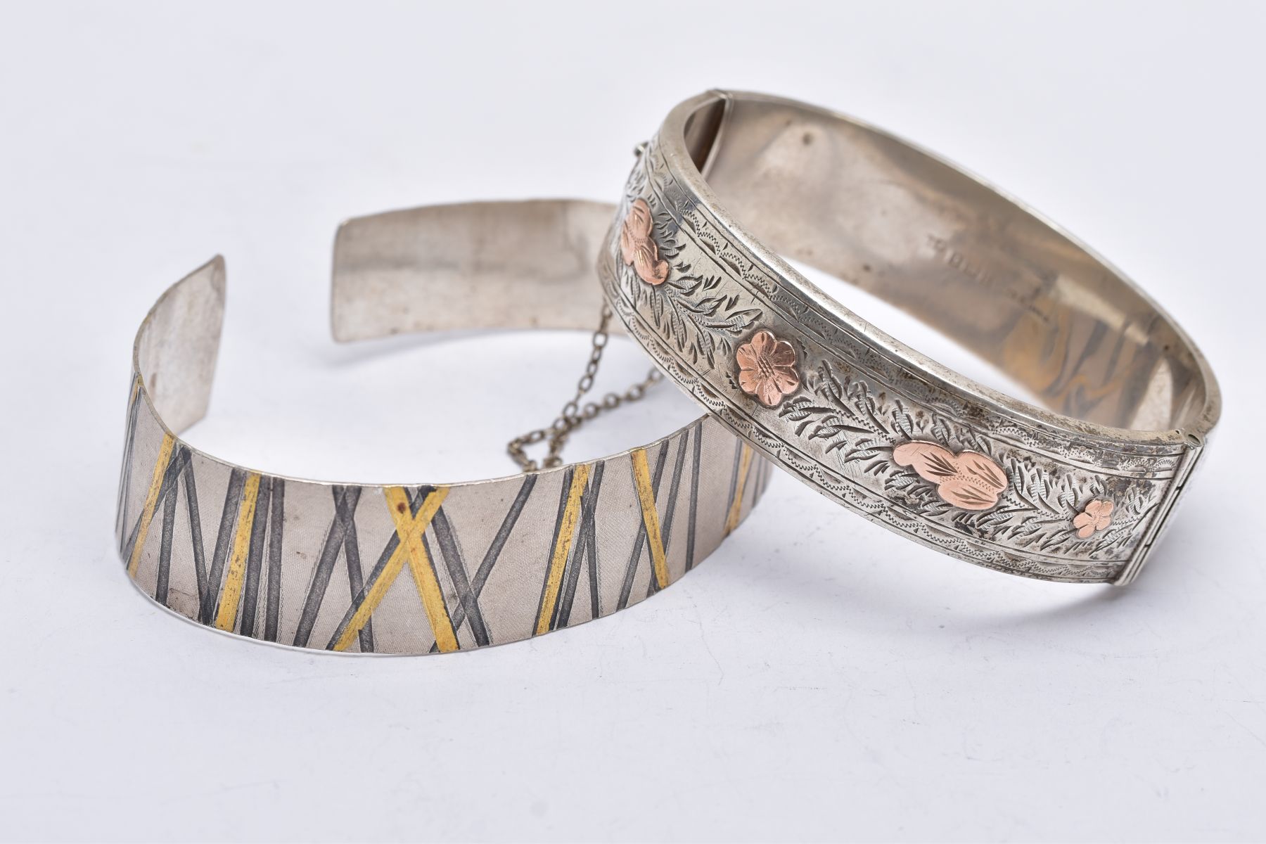 A SILVER BANGLE AND A WHITE METAL CUFF, the silver hinged bangle, with a decorative rose gold tone - Image 2 of 3