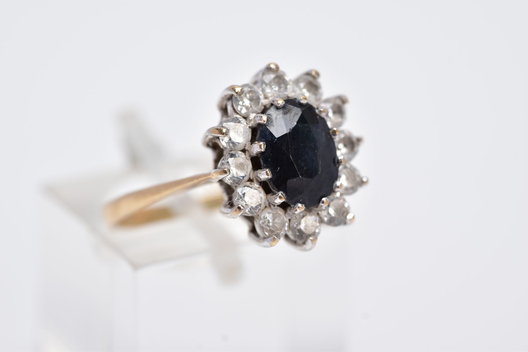 A 9CT GOLD CLUSTER RING, designed with a central oval cut blue sapphire, within a surround of claw - Image 4 of 4
