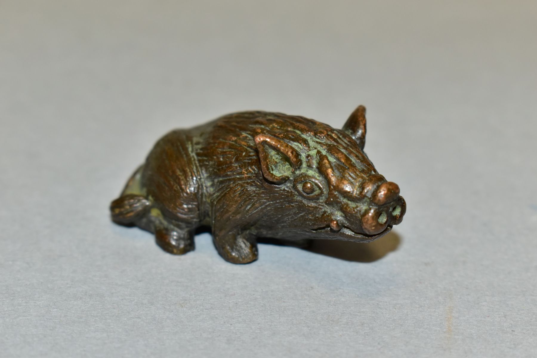 A 20TH CENTURY SMALL BRONZE FIGURE OF A SEATED HOG, unmarked, height 2.2cm x length 5.1cm