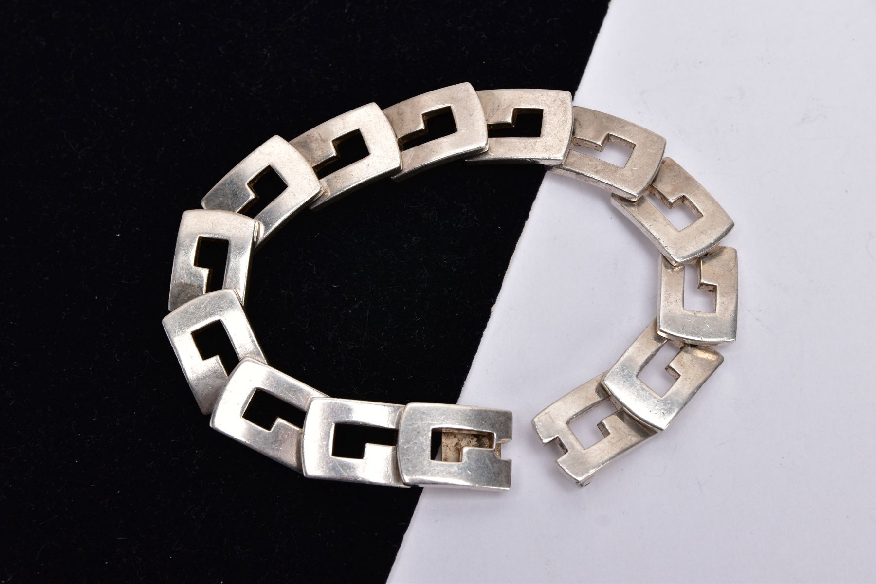 A SILVER 'GUCCI' LINE BRACELET, of an articulated design fitted with fourteen openwork rectangular