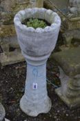 A COMPOSITE COOPERED EFFECT PLANTER, on a separate plinth, diameter 30cm x height 81cm