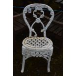 A WHITE PAINTED CAST IRON GARDEN CHAIR with a scrolled floral and scroll detail, and a lattice seat,