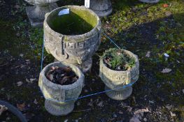 A SET OF THREE COMPOSITE GARDEN URNS, include a circular urn and a smaller pair of urns (3)