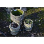 A SET OF THREE COMPOSITE GARDEN URNS, include a circular urn and a smaller pair of urns (3)