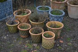 SEVEN SIMILAR CIRCULAR TERRACOTTA PLANT POTS, mostly of different sizes, with lattice work detail,