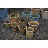 SEVEN SIMILAR CIRCULAR TERRACOTTA PLANT POTS, mostly of different sizes, with lattice work detail,