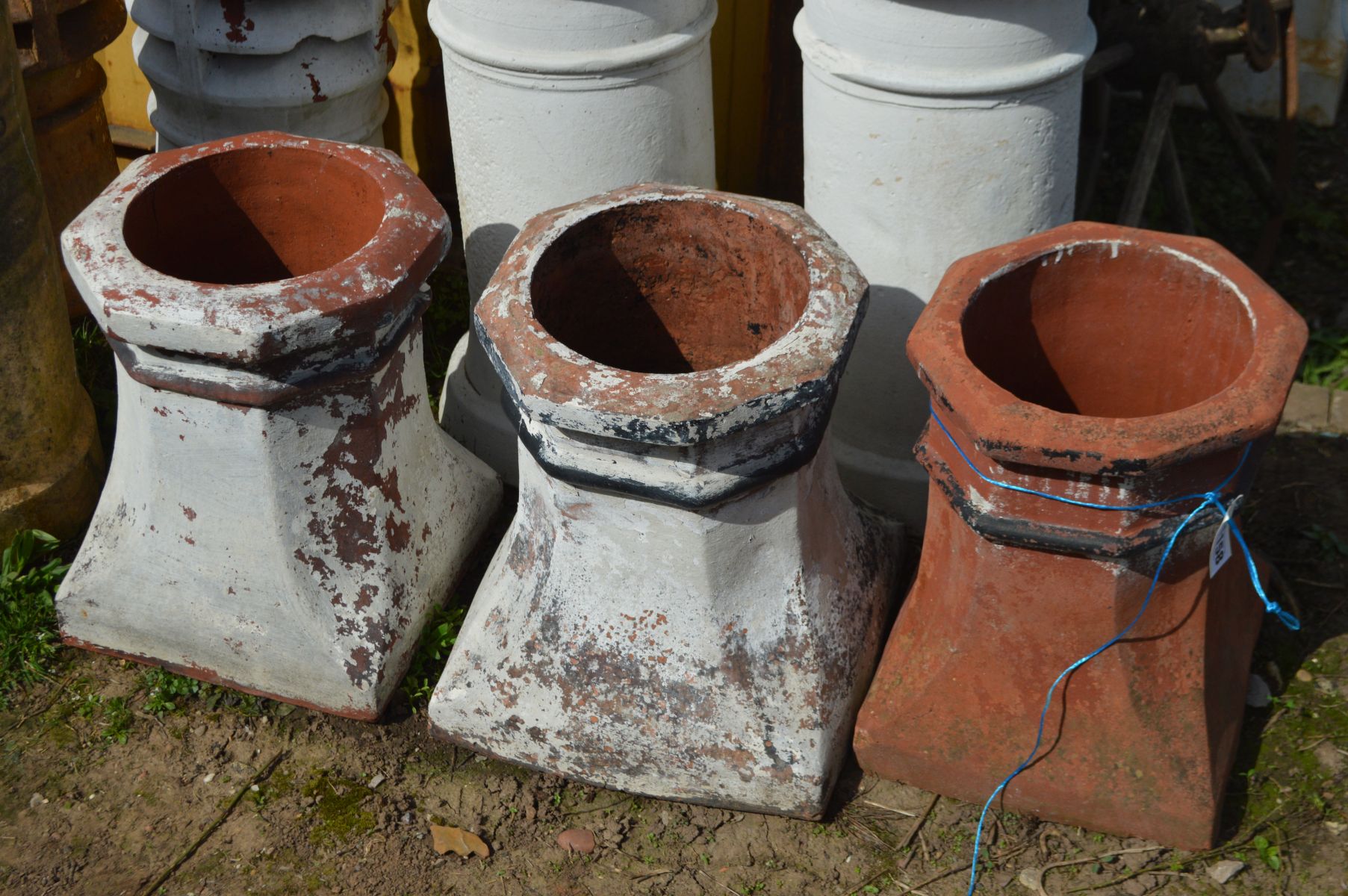 THREE OCTAGONAL TOPPED TERRACOTTA CHIMNEY POTS, two pots painted white, and two cylindrical - Image 2 of 3