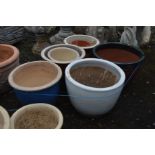 SIX VARIOUS GLAZED PLANT POTS OF VARIOUS COLOURS AND SIZES, largest diameter 47cm x height 34cm