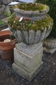 A LARGE WEATHERED COMPOSITE CAMPANA GARDEN URN, on a separate square plinth, diameter 54cm x