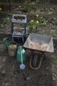 A PLASTIC HOSE REEL, along with a galvanised wheelbarrow and two watering cans (4)