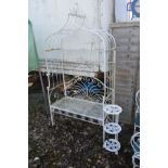 A WHITE PAINTED WROUGHT IRON GARDEN BENCH with an arched overhanging top, width 110cm x depth 51cm x