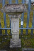 A COMPOSITE CORINTHUM AND REEDED COLUMN BIRD BATH, 39cm squared x height 94cm (repair to column)