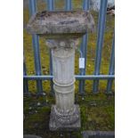 A COMPOSITE CORINTHUM AND REEDED COLUMN BIRD BATH, 39cm squared x height 94cm (repair to column)