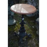 A CAST IRON PUB TABLE BASE with a loose circular orange marble top, diameter 52cm x height 73cm