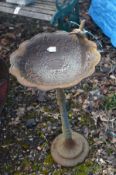 A CAST IRON BIRD BATH, with a wavy top and humming bird to the top edge, diameter 37cm x height