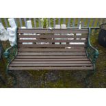 A HEAVY GREEN PAINTED METAL AND TEAK SLATTED BENCH, with lions head to the armrests, width 131cm