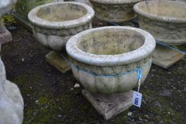 A PAIR OF COMPOSITE CIRCULAR URNS on separate bases, diameter 36cm x height 33cm