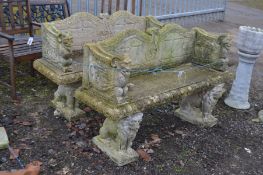 A PAIR OF WEATHERED COMPOSITE GARDEN BENCHES, with raised back sides, the armrests depicting