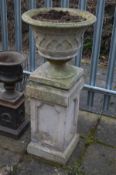 A COMPOSITE CIRCULAR URN, with lattice work detail, on a square base, and a separate pillar,