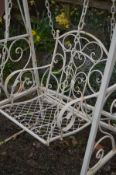 A WROUGHT IRON SINGLE SEATER GARDEN SWING, painted in white, with scrollage decoration, width