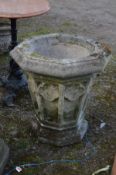 A WEATHERED COMPOSTITE ECCLESIASTICAL GARDEN PLANTER, of a tapered octagonal form and with