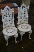 A PAIR OF HEAVY CAST IRON CHAIRS, each with high backs, with curved cresting rails, pierced floral