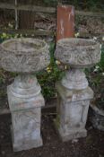 A PAIR OF COMPOSITE GARDEN PLANTERS with acanthus leaf detail, on a tall matched plinth, diameter