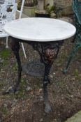 A CIRCULAR CAST IRON PUB TABLE with a separate white marble top and undertier, diameter 56cm x