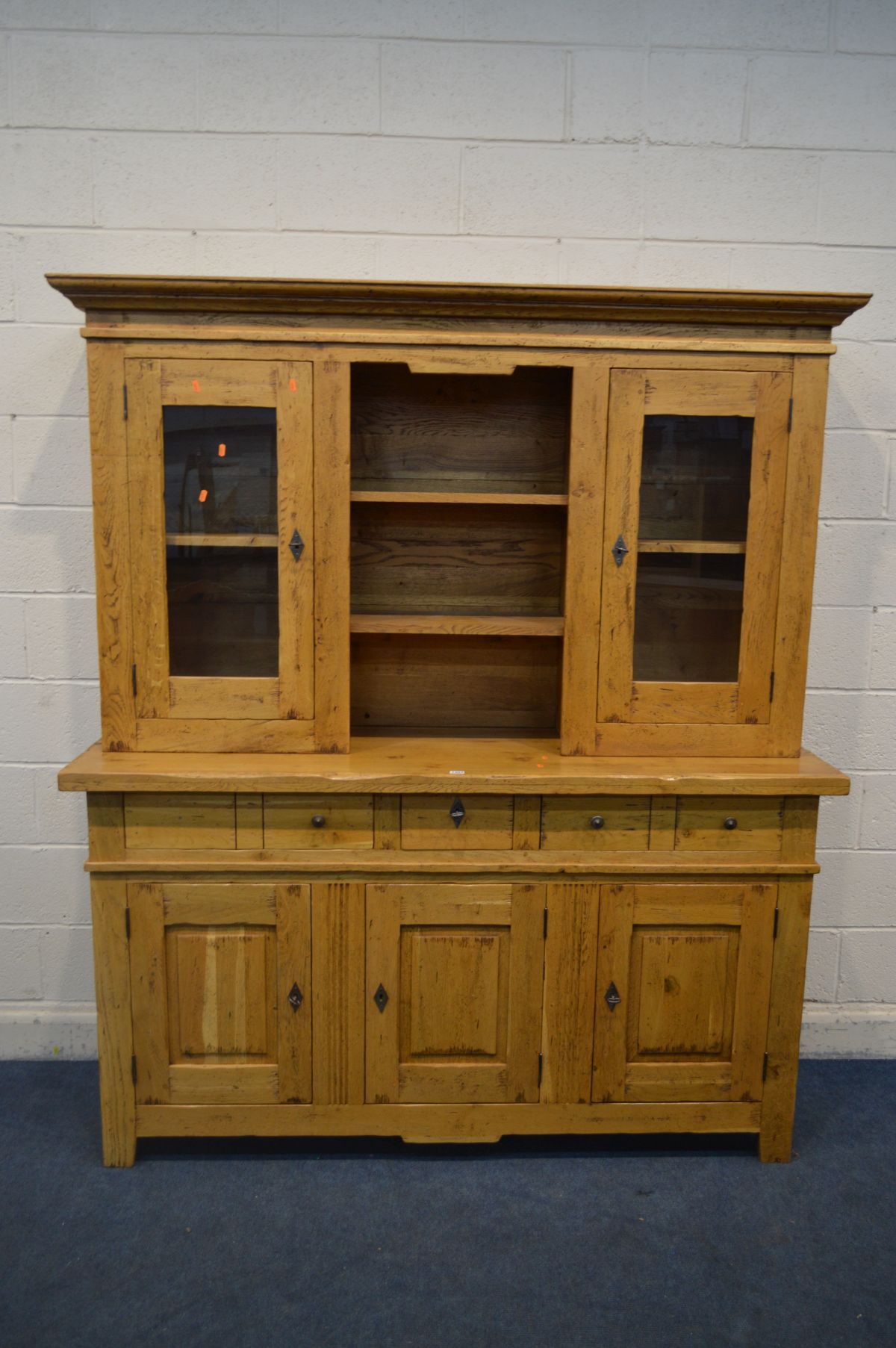 A GOLDEN OAK DRESSER, the top with double glazed doors flanking open shelves, above a base with