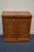 A HARDWOOD DRINKS BAR, with heavily carved panels, with a double fold over top and two doors