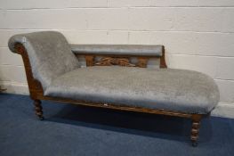 A EDWARDIAN CARVED OAK CHAISE LONGUE, reupholstered in grey, length 177cm