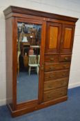 AN EDWARDIAN WALNUT COMPACTUM WARDROBE, with a single mirror door and six drawers, width 195cm x