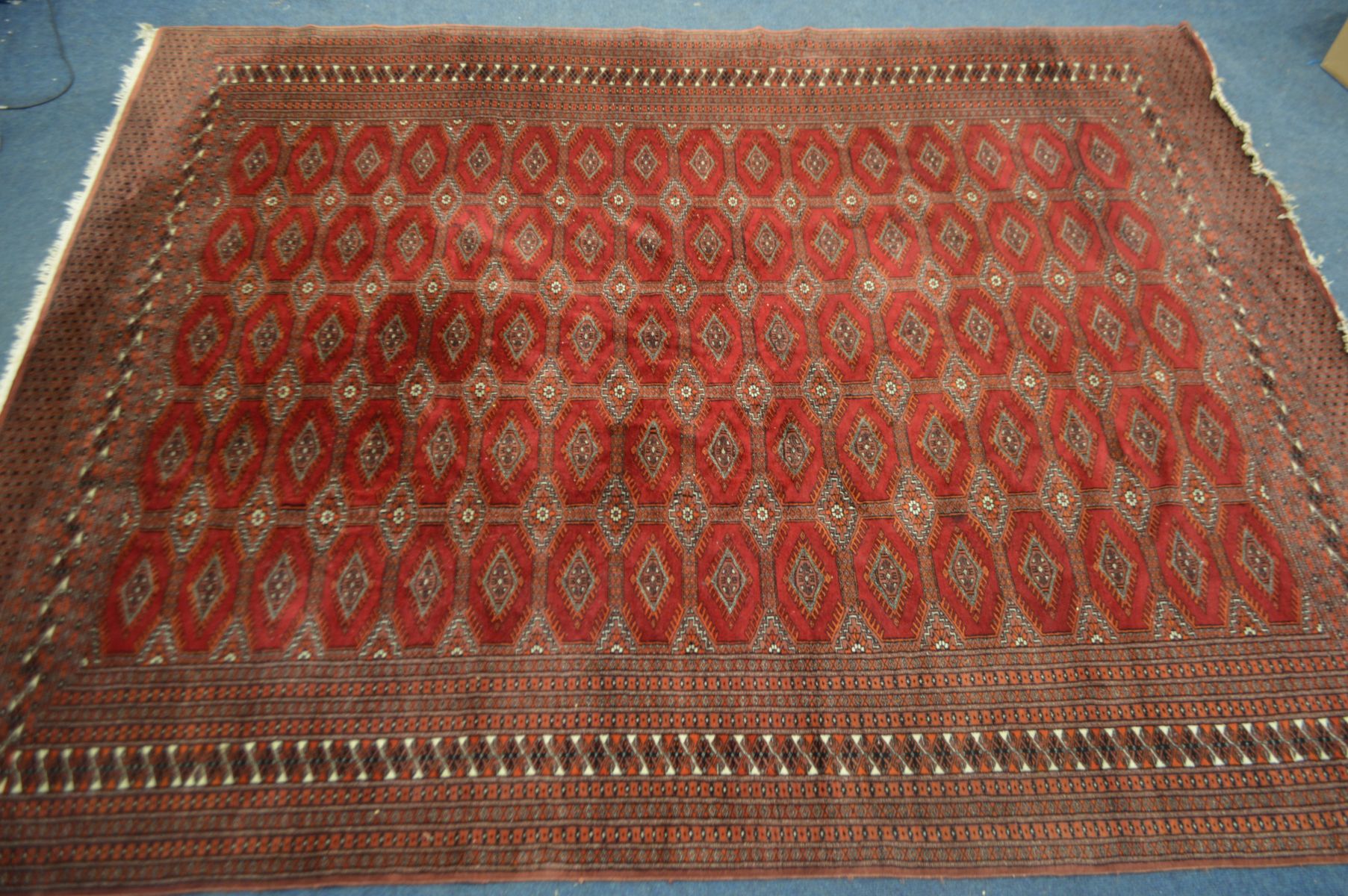 A TEKKE BOKHARA RED GROUND RUG, 320cm x 250cm (Sd to tassels)