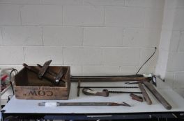 A VINTAGE WOODEN BOX CONTAINING VINTAGE TOOLS including a 19C Dutch Hoe, axe, a Muck Knuckler, a