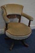 AN EDWARDIAN OAK SWIVEL TUB CHAIR, later reupholstered