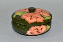 A MOORCROFT POTTERY POWDER BOWL AND COVER DECORATED IN CORAL HIBISCUS, green ground, impressed and