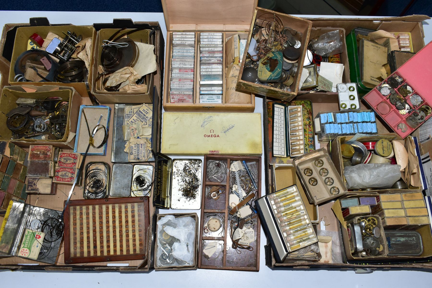 TWO BOXES OF ASSORTED WATCH MAKERS PARTS, GLASSES, COGS, SPRINGS, CROWNS, DECONSTTUCTED WATCH