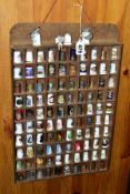 JUST OVER 100 DECORATIVE THIMBLES, together with two wooden display shelves
