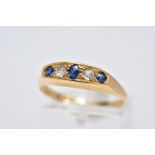 AN 18CT GOLD FIVE STONE RING, of a boat shape, set with a central oval cut blue sapphire interspaced