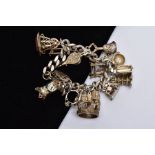 A SILVER CHARM BRACELET, bracelet hallmarked London 1970, suspending fifteen white metal charms in