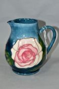 A MOORCROFT POTTERY COLLECTORS CLUB JUG DECORATED WITH PINK ROSES, on a shaded blue ground, printed,