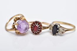 THREE 9CT GOLD GEM SET RINGS, to include an oval cut amethyst set with an openwork scallop edge