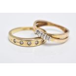 TWO 9CT GOLD DIAMOND RINGS, the first of a crossover design, set with three round brilliant cut