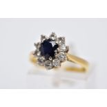 AN 18CT GOLD, SAPPHIRE AND DIAMOND CLUSTER RING, designed with a central oval cut blue sapphire,