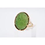 A 9CT GOLD, CARVED NEPHRITE CAMEO RING, of an oval form with a carved floral design, beaded