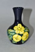 A MOORCROFT POTTERY SQUAT BALUSTER VASE, decorated in a yellow buttercup pattern on a dark blue