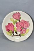 A MOORCROFT POTTERY MAGNOLIA PATTERN PLATE, on a cream ground, painted WM signature, painted and